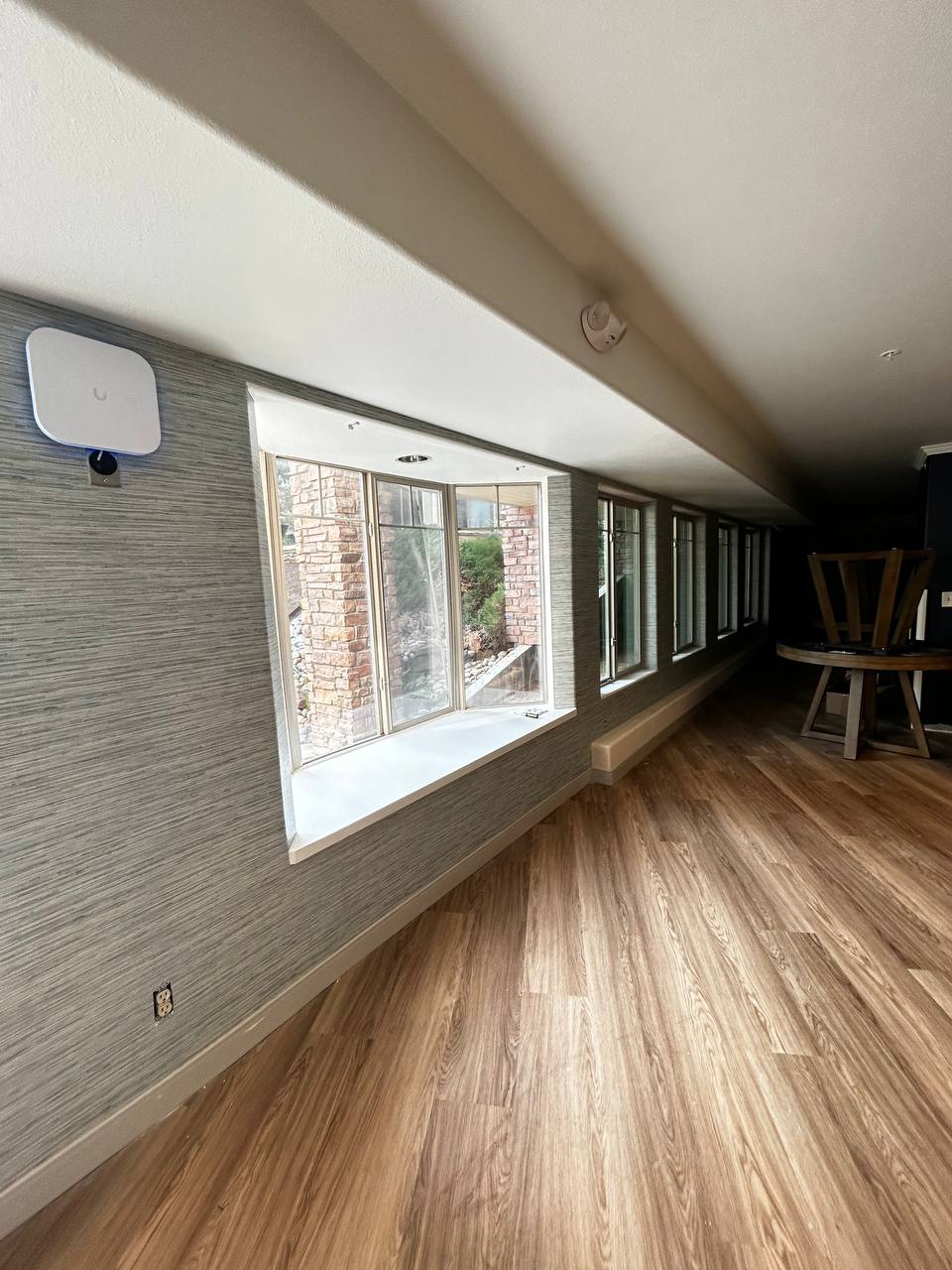 Modern conference room featuring grey textured wall paneling or coverings on the right wall, complementing the acoustic ceiling panels.
