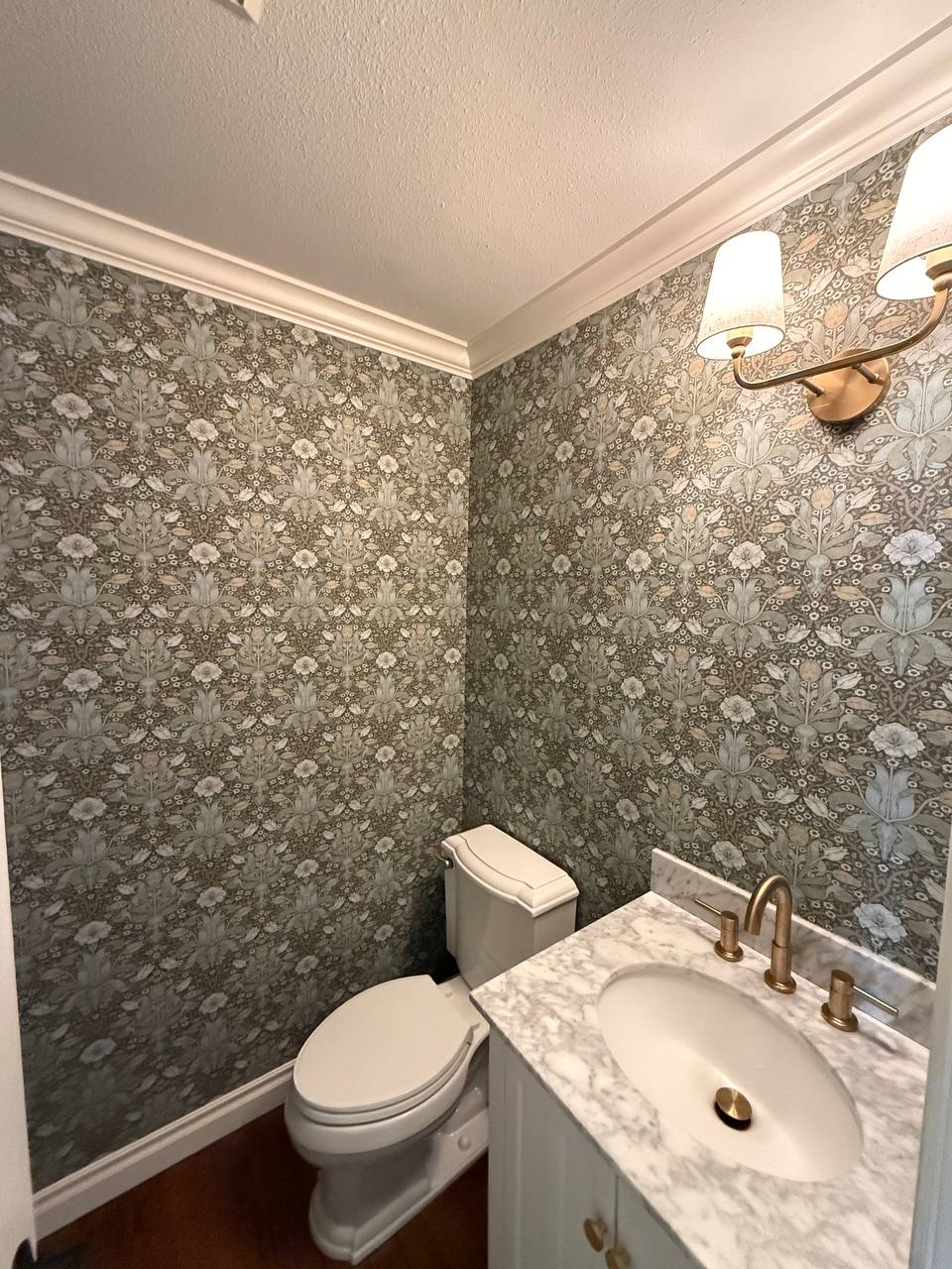 Stylish bathroom interior with deep navy blue walls and a striking black-and-white wavy geometric patterned wallpaper accent wall behind the toilet.
